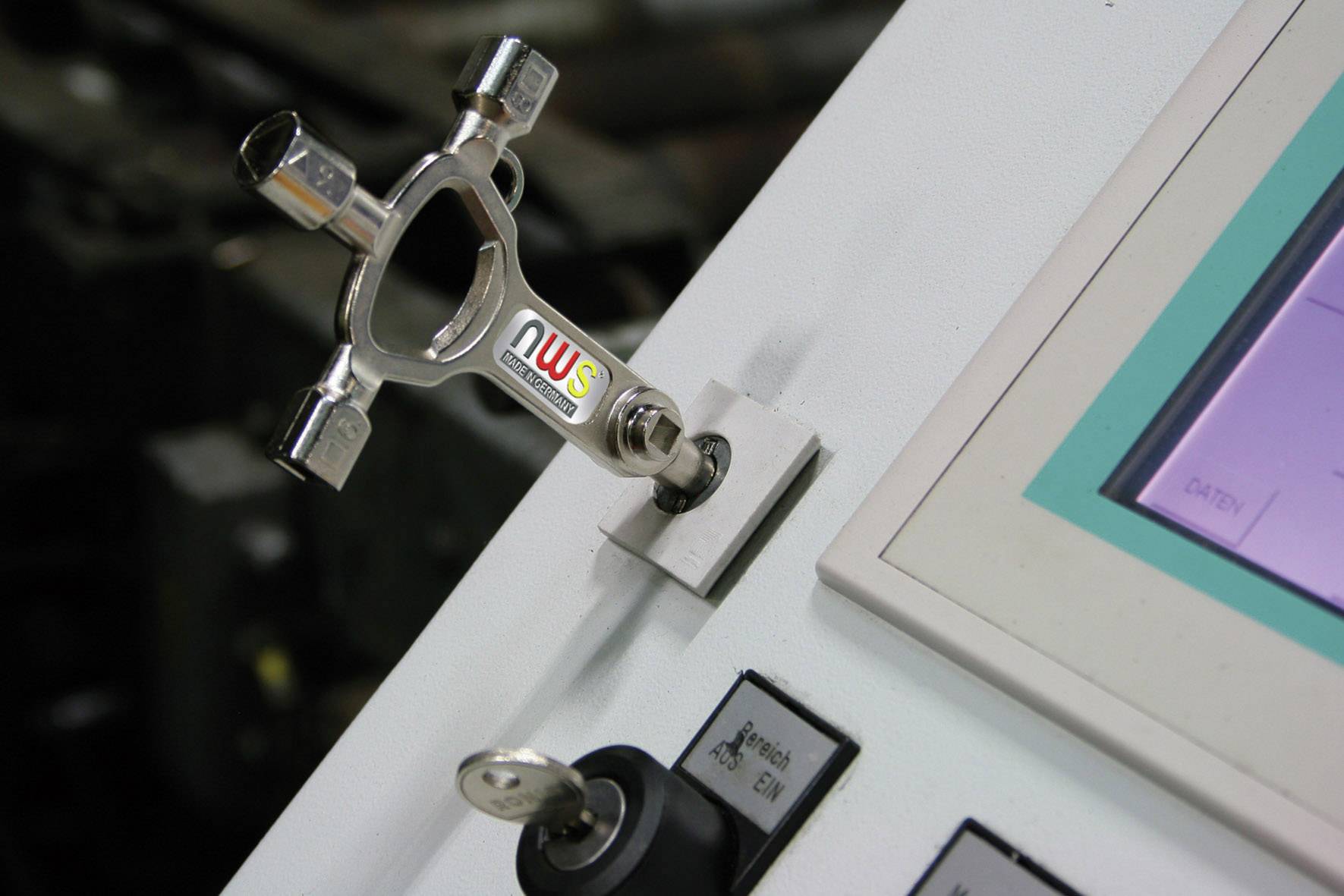 Hebelförmiger Schlüssel an einem Bedienfeld mit Display und Schlüsselschalter montiert, dient zur Steuerung oder Sicherung einer Maschine.