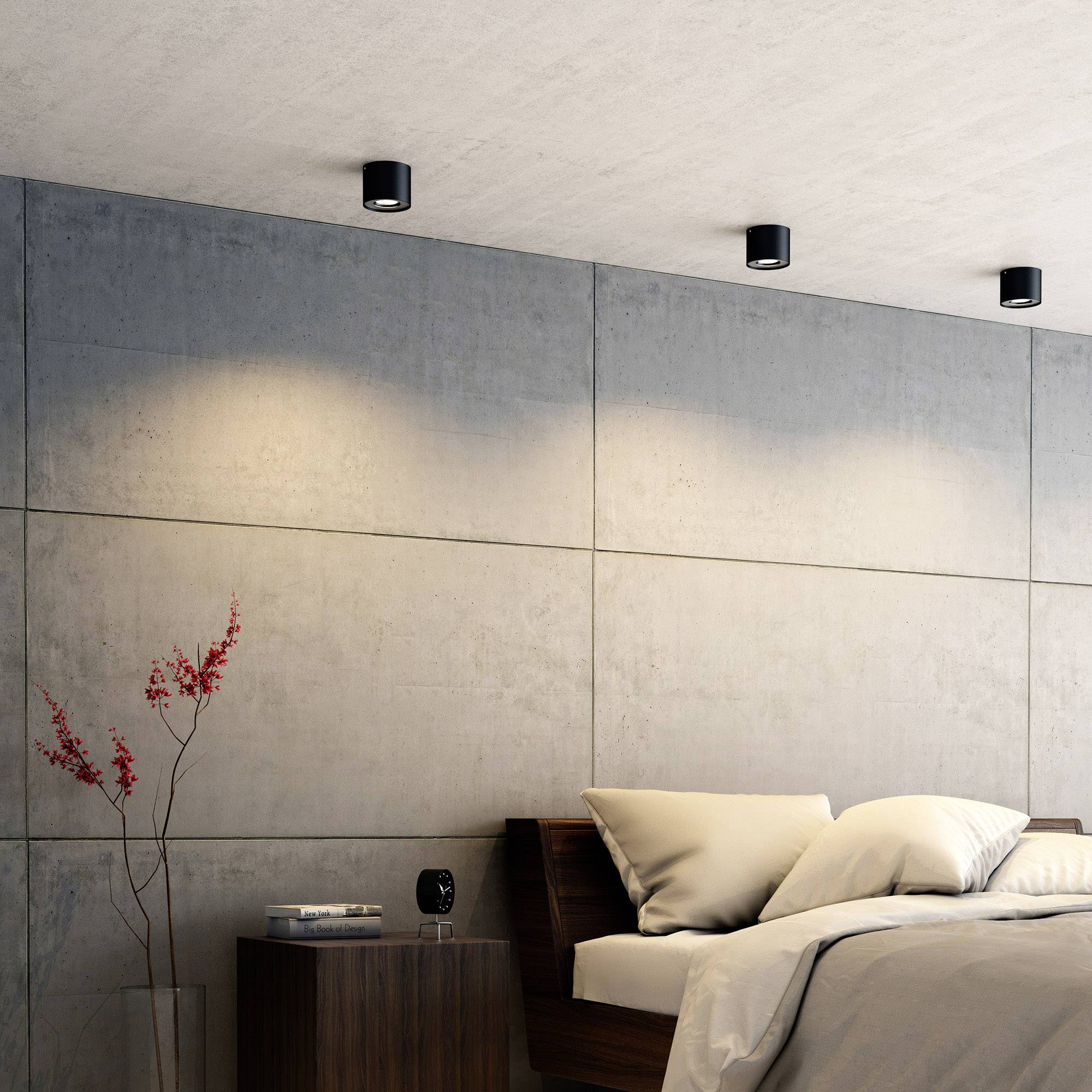 Schlafzimmer mit modernem Design, Betonwand, Nachttisch mit Vase, und Deckenleuchten, gemütliches Ambiente.
