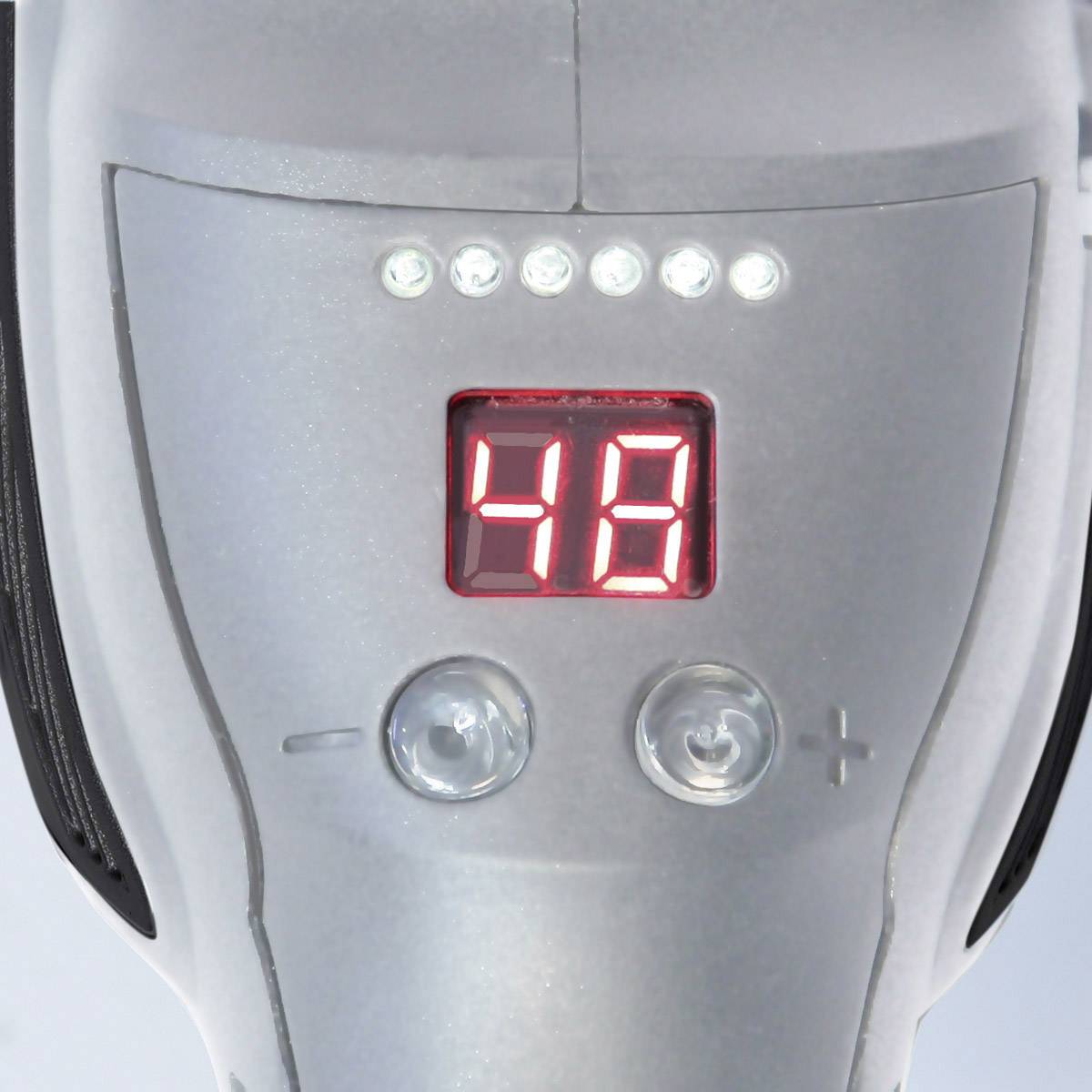 Digitalanzeige eines Geräts zeigt die Zahl '48'. Daneben sind Bedientasten, darunter '+' und '-', sichtbar.