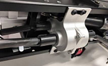 Nahaufnahme einer Metallhalterung mit zwei verbundenen Kabeln. Die Halterung ist stabil befestigt und Teil einer größeren Maschinenstruktur.