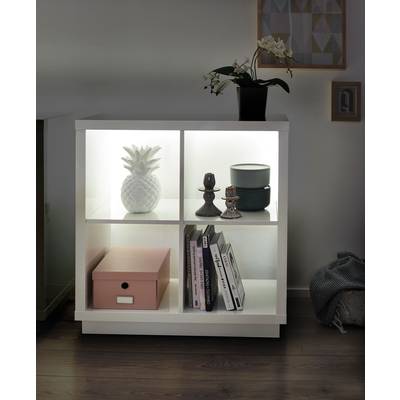 Weißes Regal mit Beleuchtung, darin eine weiße Ananas, Buchstützen, Bücher und eine pinke Box. Oben eine Orchidee.