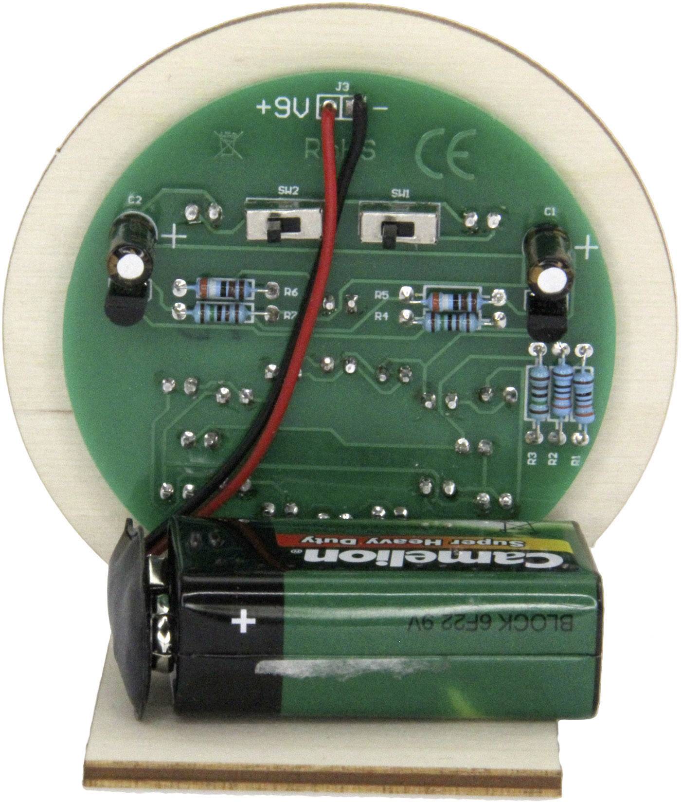 Eine grüne Schaltplatte mit elektronischen Komponenten und einer angeschlossenen 9V-Batterie.