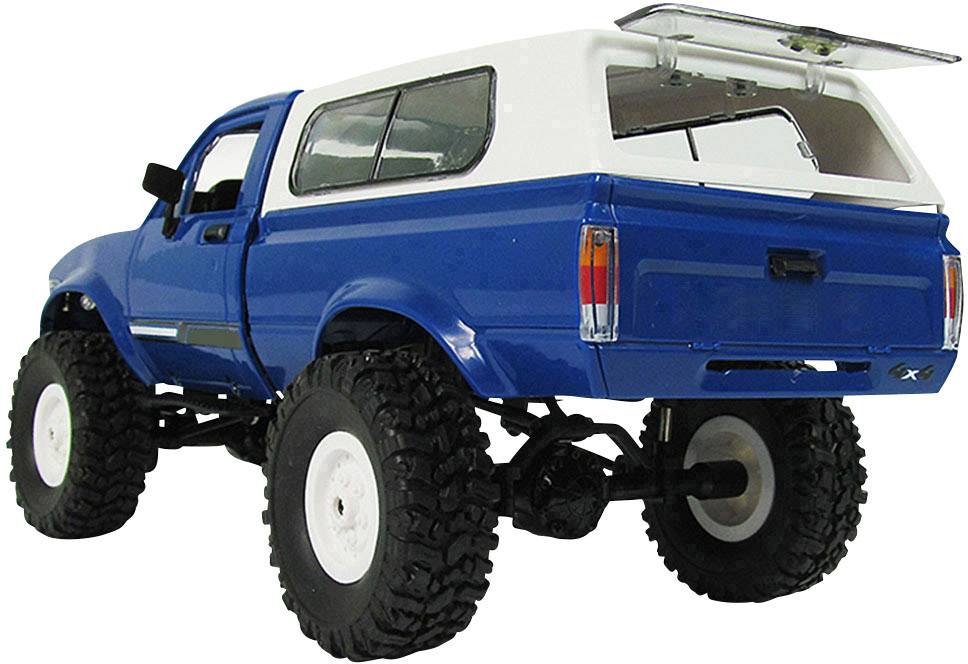 Blauer Geländewagen mit weißem Dach, großen Reifen und Antenne, betrachtet von hinten schräg links.