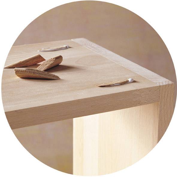 Nahaufnahme eines Holzdübels und Holzspänen auf einem Tisch.