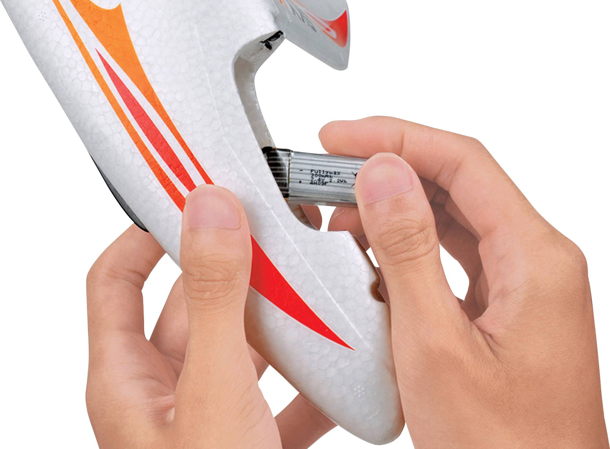 Hände setzen eine Batterie in ein weißes Spielzeugflugzeug mit roten und orangefarbenen Streifen ein.