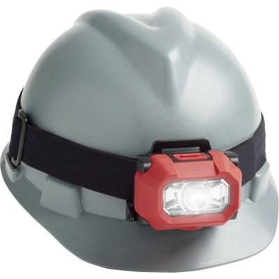 Ein grauer Bauhelm mit einer roten Stirnlampe, die an einem schwarzen Band befestigt ist. Die Lampe leuchtet hell nach vorne.