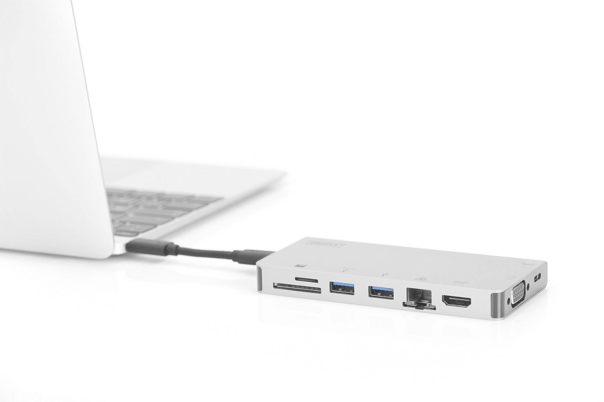 Ein Laptop ist mit einem externen Adapter verbunden, der mehrere Anschlüsse wie USB, HDMI und Ethernet bietet.