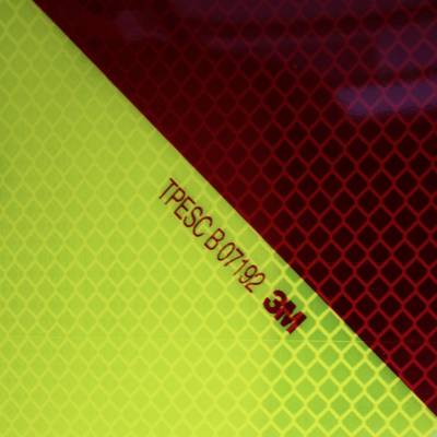 Reflektierende Oberfläche mit roten und gelben Bereichen. Der Code 'TPESC B07192 3M' ist in der Mitte eingraviert.