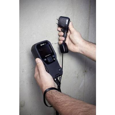 Ein Handgerät wird an eine Betonwand gehalten, um Werte auf dem Display zu messen.