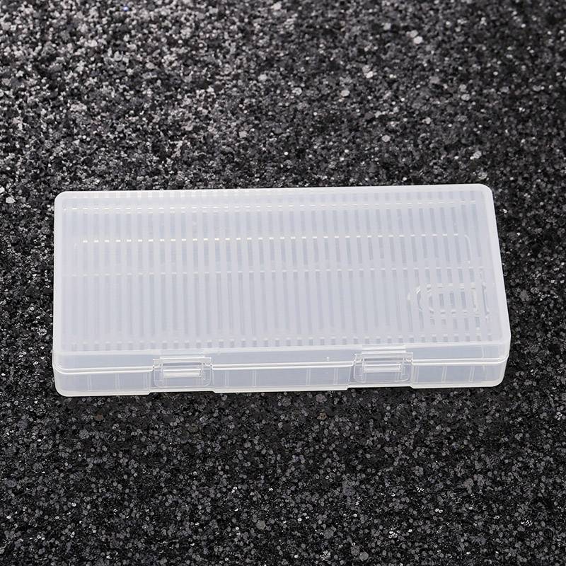 Transparente, rechteckige Kunststoffbox auf dunklem, körnigen Untergrund. Box hat ein Gittermuster und einen Klickverschluss.