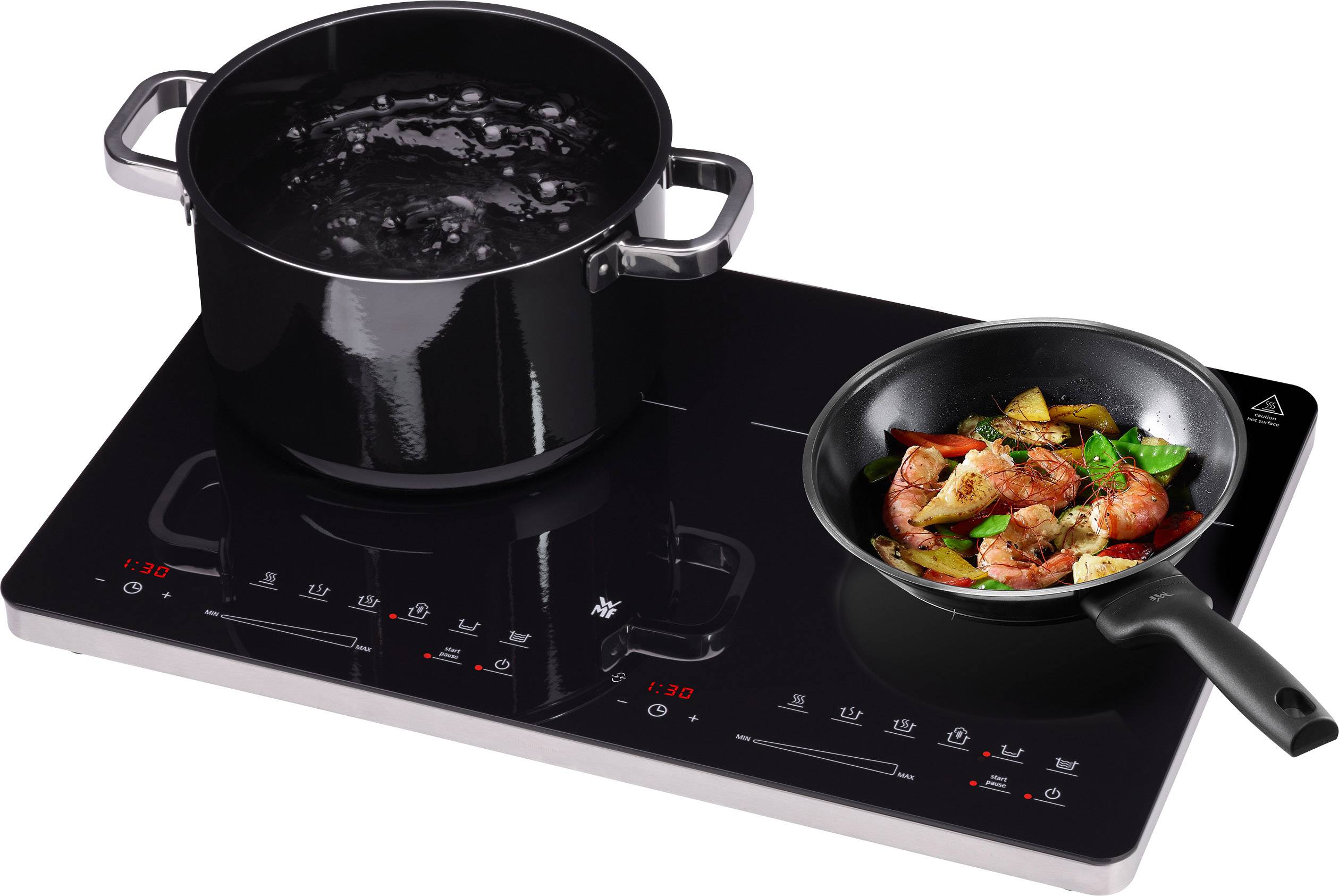 Elektroherd mit zwei Kochplatten: Links steht ein Topf mit kochendem Wasser, rechts eine Pfanne mit gebratenem Gemüse.