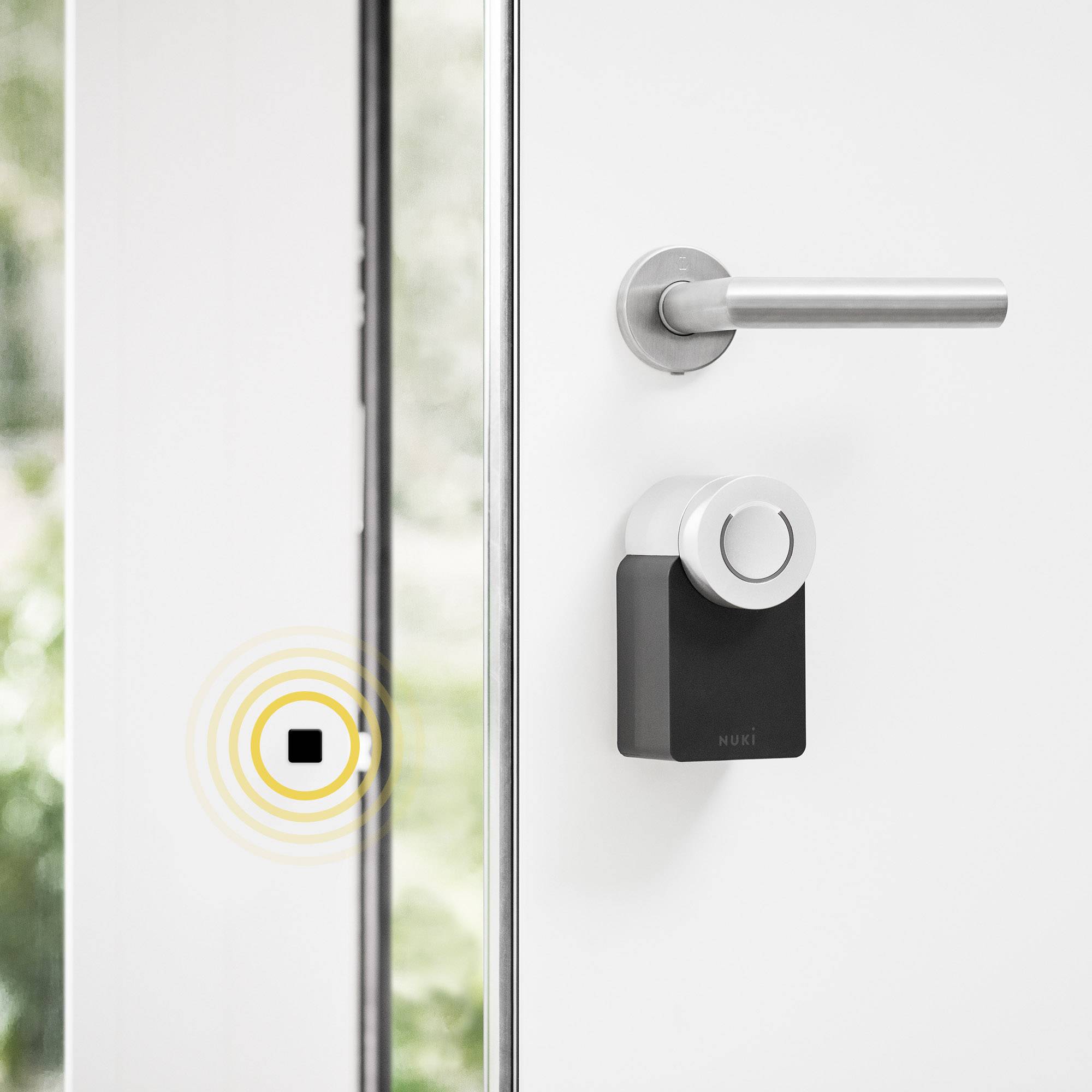 Ein Smartlock ist an einer weißen Tür angebracht. Ein Smartphone-Symbol mit Signalwellen zeigt die Möglichkeit der Fernsteuerung.