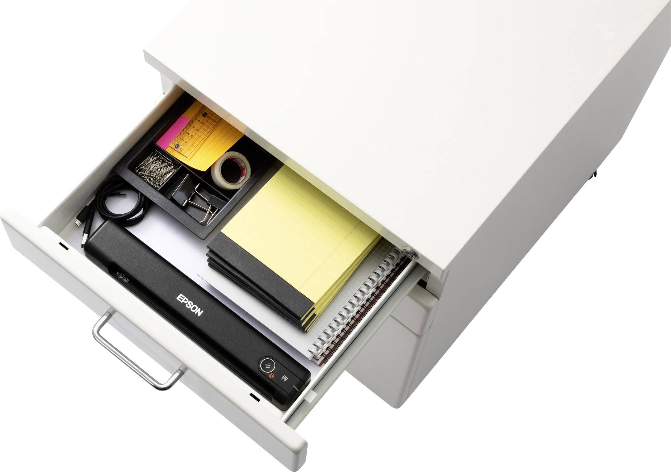 Offene Schublade mit Laptop, Notizblöcken, Büroklammern und Klebeband, organisiert für einen Büroschreibtisch.