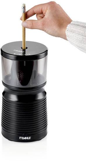 Eine Hand hält einen Bleistift und steckt ihn in einen elektrischen Anspitzer. Der Anspitzer hat ein modernes, schwarzes Design.