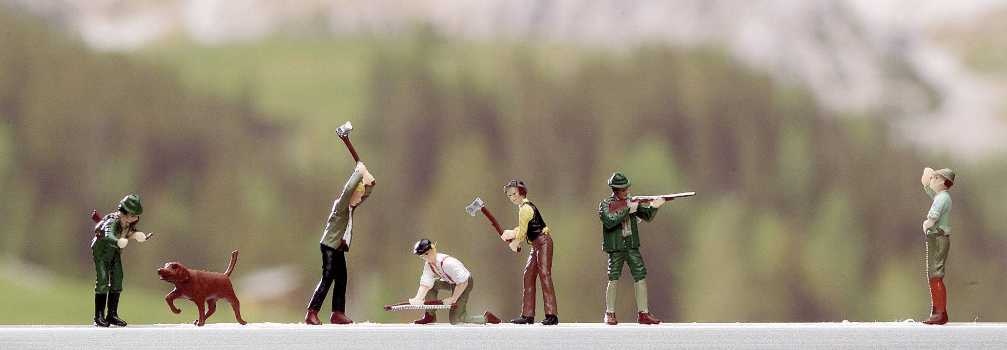 Kleine Figuren bei der Arbeit im Freien: Drei Personen mit Äxten, eine kniend, ein Mann mit Gewehr, eine Frau mit Hund. Hintergrund unscharf.