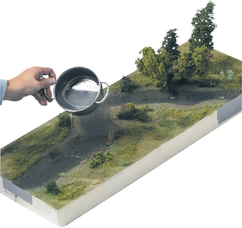 Ein Modell zeigt einen Landschaftsabschnitt mit Bäumen und Flüssen. Eine Hand gießt Wasser aus einem Krug auf das Gelände.