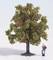 Eine Miniaturfigur lehnt an einem Modell-Apfelbaum mit vielen roten Äpfeln.