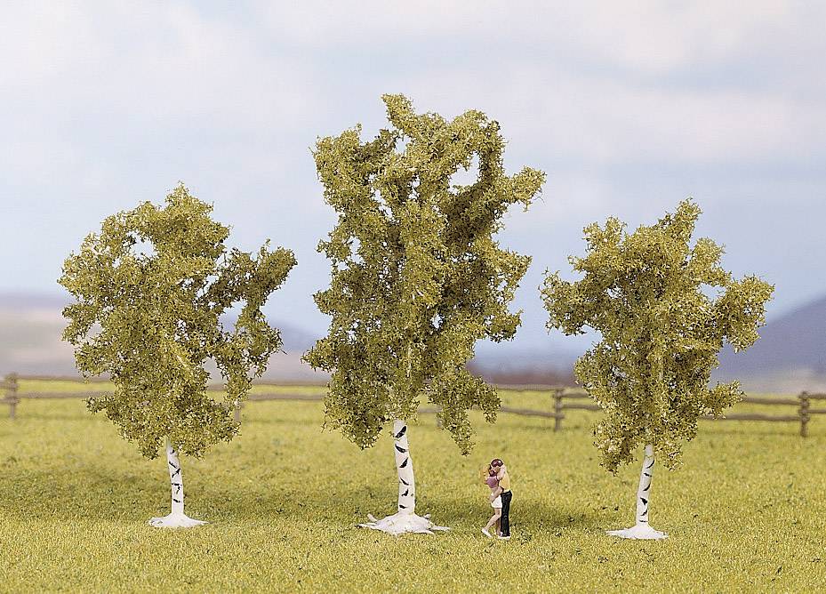 Eine Person umarmt einen Baum in einer Reihe von drei Laubbäumen auf einem grasbewachsenen Feld vor einem Holzzaun.
