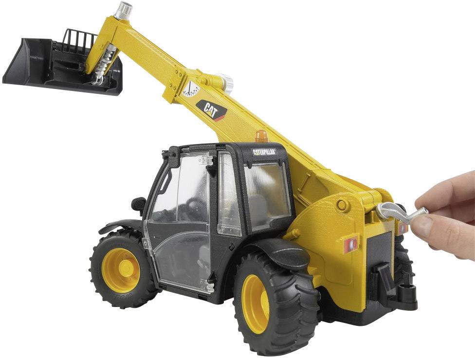 Ein gelber Teleskoplader mit Schaufel wird von einer Spielzeugfigur bedient. Die Schaufel ist angehoben, und der Lader steht auf großen Reifen.