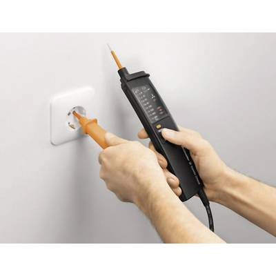 Eine Person testet eine Steckdose mit einem Spannungsprüfer. Sie misst die Spannung zur Überprüfung der elektrischen Sicherheit.