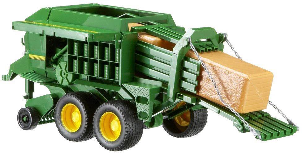 Spielzeug-Heuwagenmodell in Grün mit gelben Rädern und rotem Pressgut. Kette sichert Ladung.