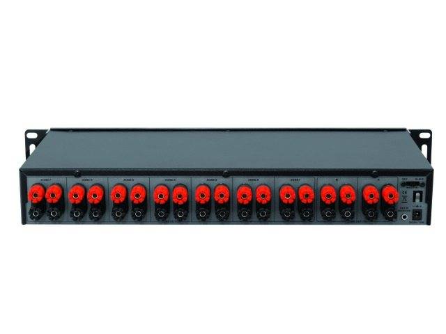 'Rückseite eines Soundgeräts mit Anschlussbuchsen und Schaltern, geeignet für die Verbindung mehrerer Audiokanäle in einem Rack. Red und schwarze Anschlüsse erleichtern die Unterscheidung.'