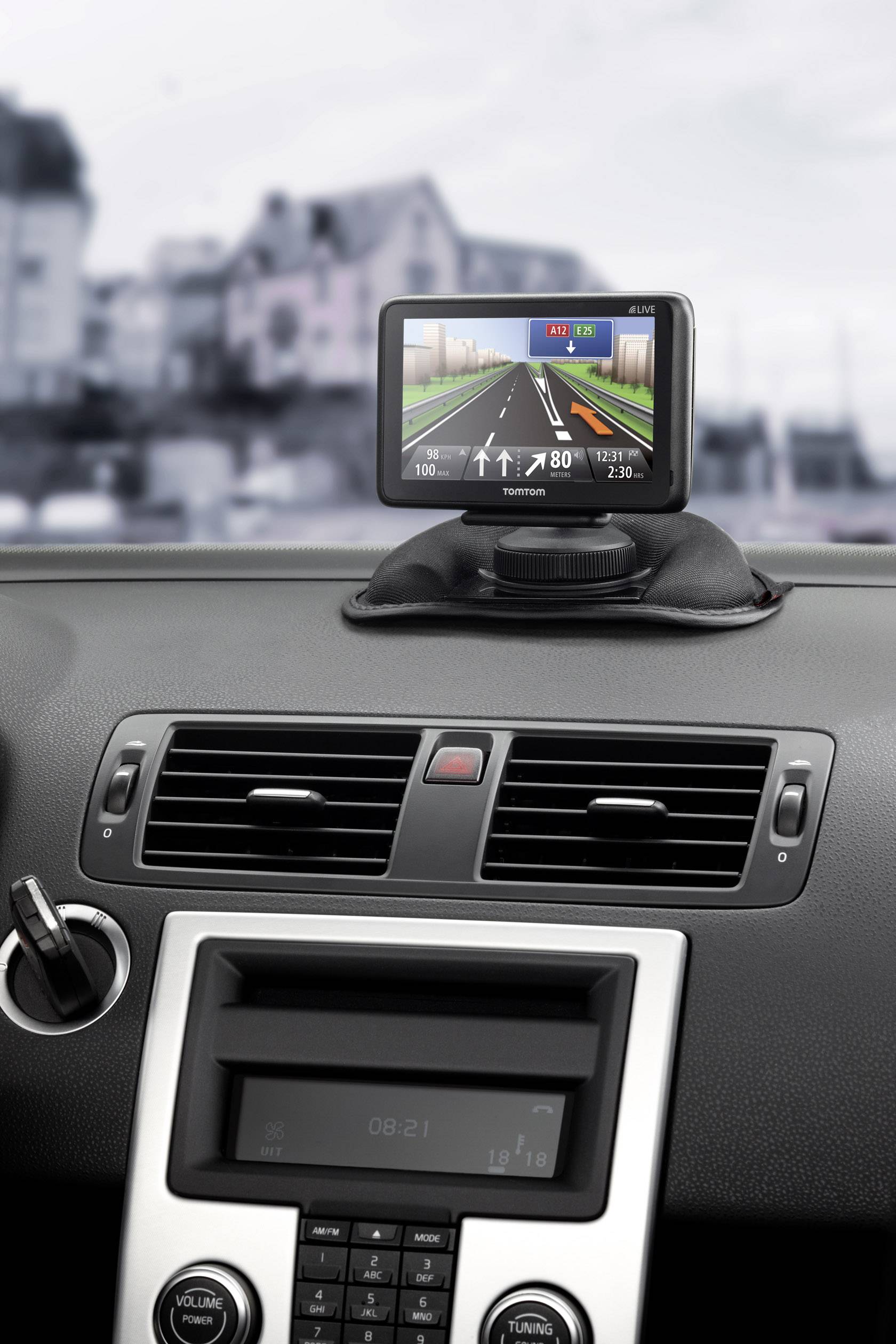 Navigationsgerät auf dem Armaturenbrett eines Autos, zeigt eine Straßenkarte mit Fahranweisungen und einem digitalen Tacho an.