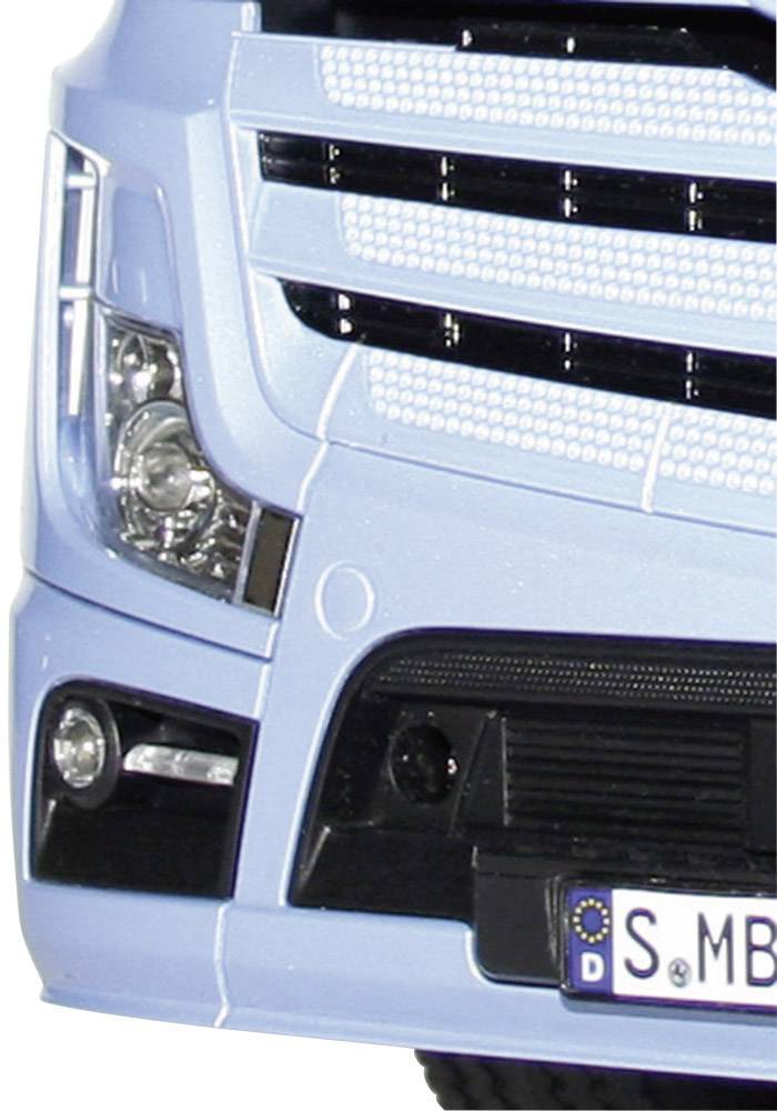 Die Front eines hellblauen LKWs mit glänzendem Kühlergrill und Scheinwerfern. Ein deutsches Nummernschild ist sichtbar.