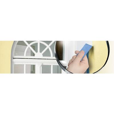 Eine Hand klebt blaues Malerband um das Fenster einer gelben Wand ab, um es vor Farbspritzern zu schützen.