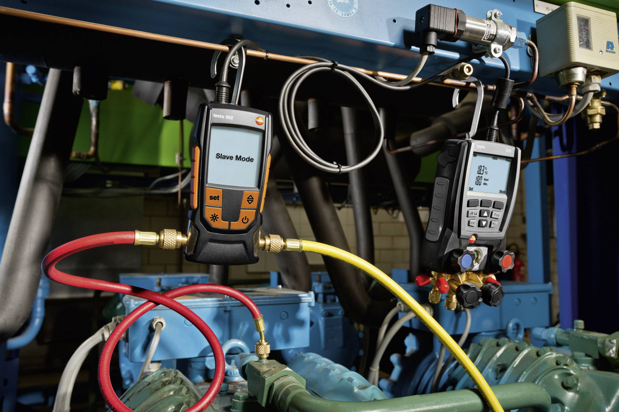 'Zwei digitale Manometer messen den Druck in einem Kühlsystem. Einer zeigt den Saugmodus an, während der andere den Druck anzeigt.'