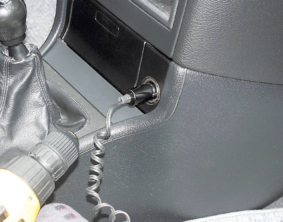 Ein Ladekabel ist an eine Autosteckdose angeschlossen.