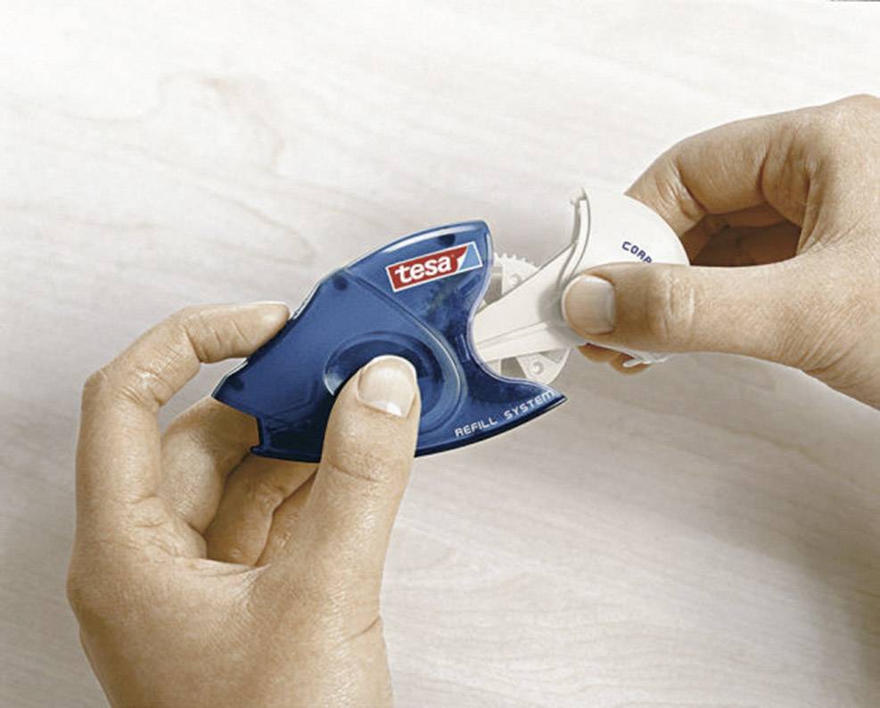 Zwei Hände halten einen Korrekturroller der Marke 'tesa' über einem hellen Tisch. Eine Hand entfernt die Kappe.