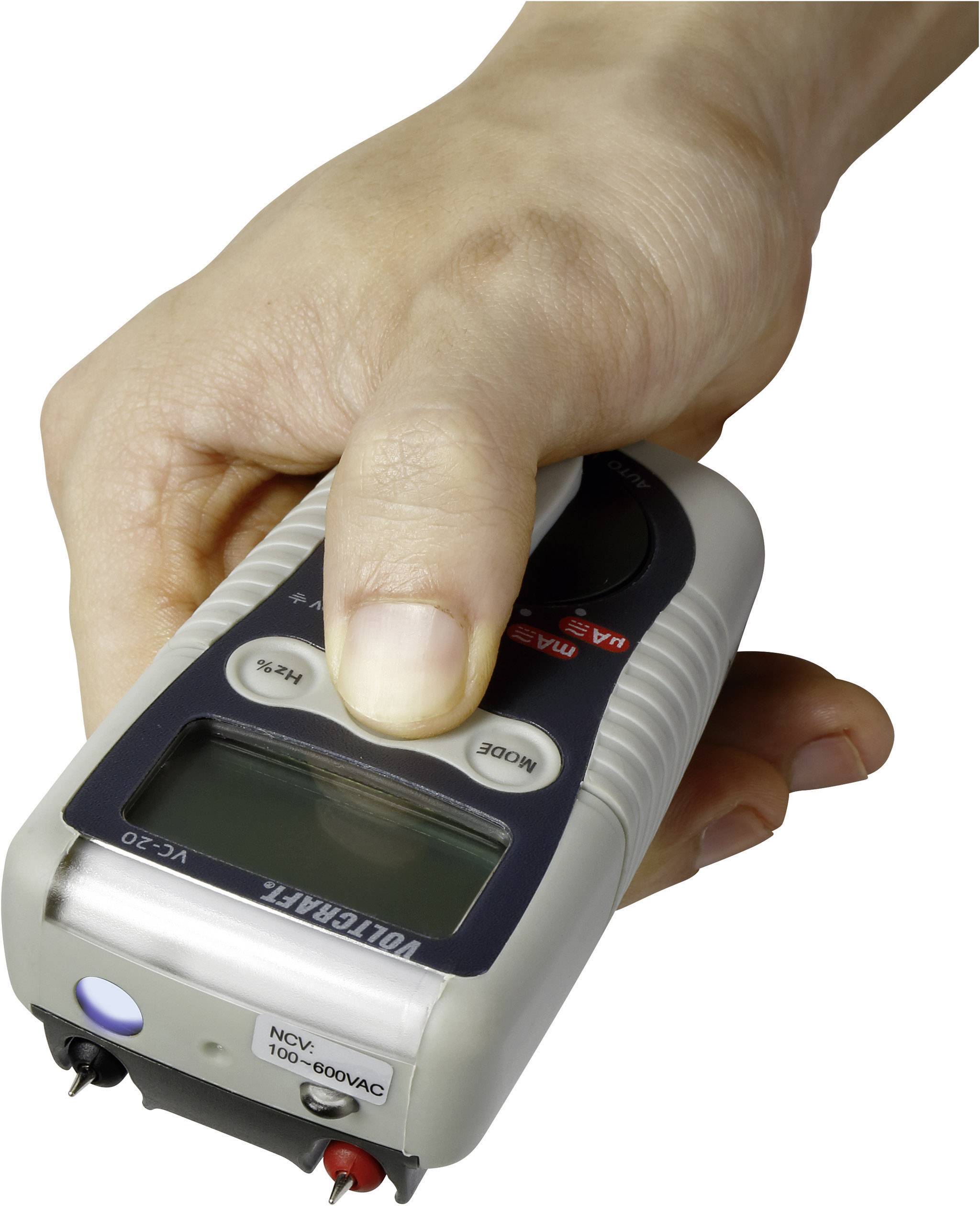 Eine Hand hält ein tragbares elektrisches Messgerät mit einem digitalen Display.