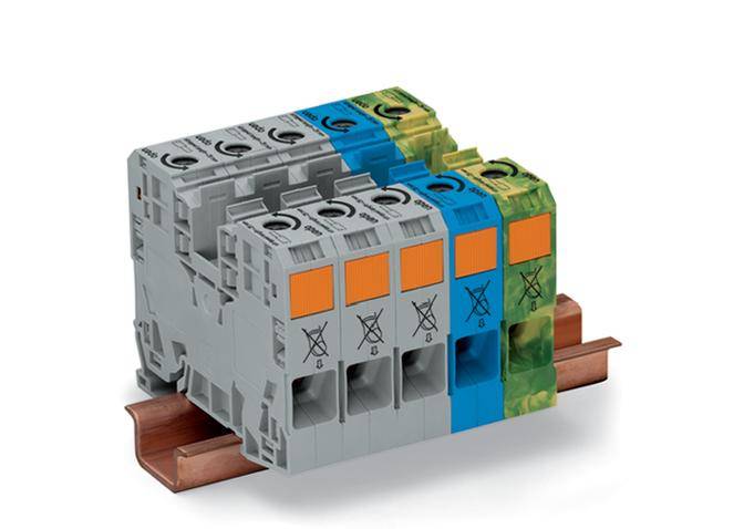 Mehrere graue elektrische Modulanschlüsse auf einer Kupferschiene, mit blauen, grünen und orangen Markierungen.