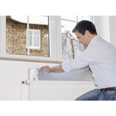 Ein Mann befestigt eine Isolierfolie hinter einem Heizkörper, um Energieeffizienz zu verbessern. Ein Fenster zeigt eine verschneite Landschaft.