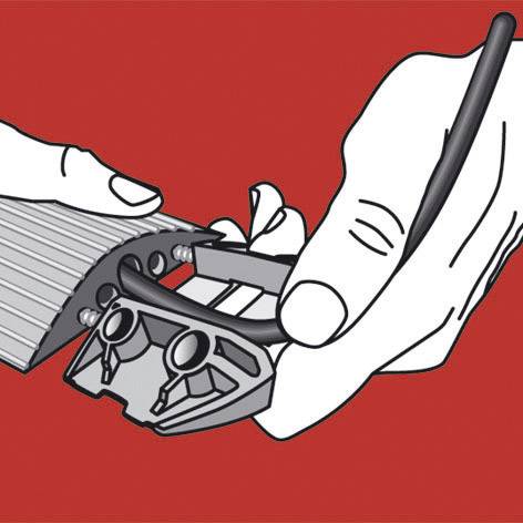 Eine Hand schärft einen Bleistift mit einem Anspitzer, der Späne sammelt. Der Hintergrund ist rot.