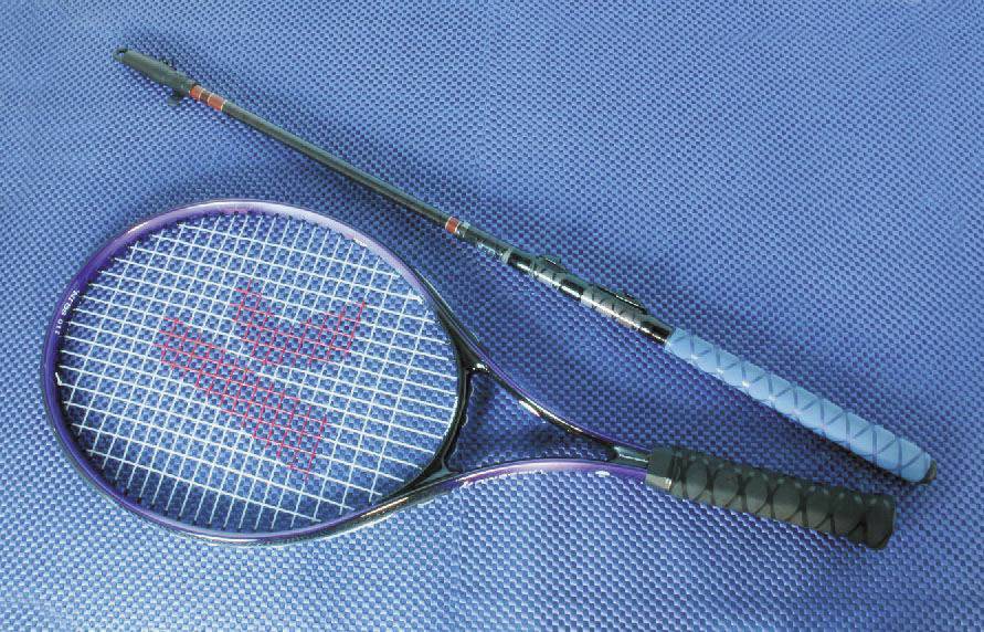 Ein Tennis- und ein Badmintonschläger liegen nebeneinander auf einer blauen Matte.
