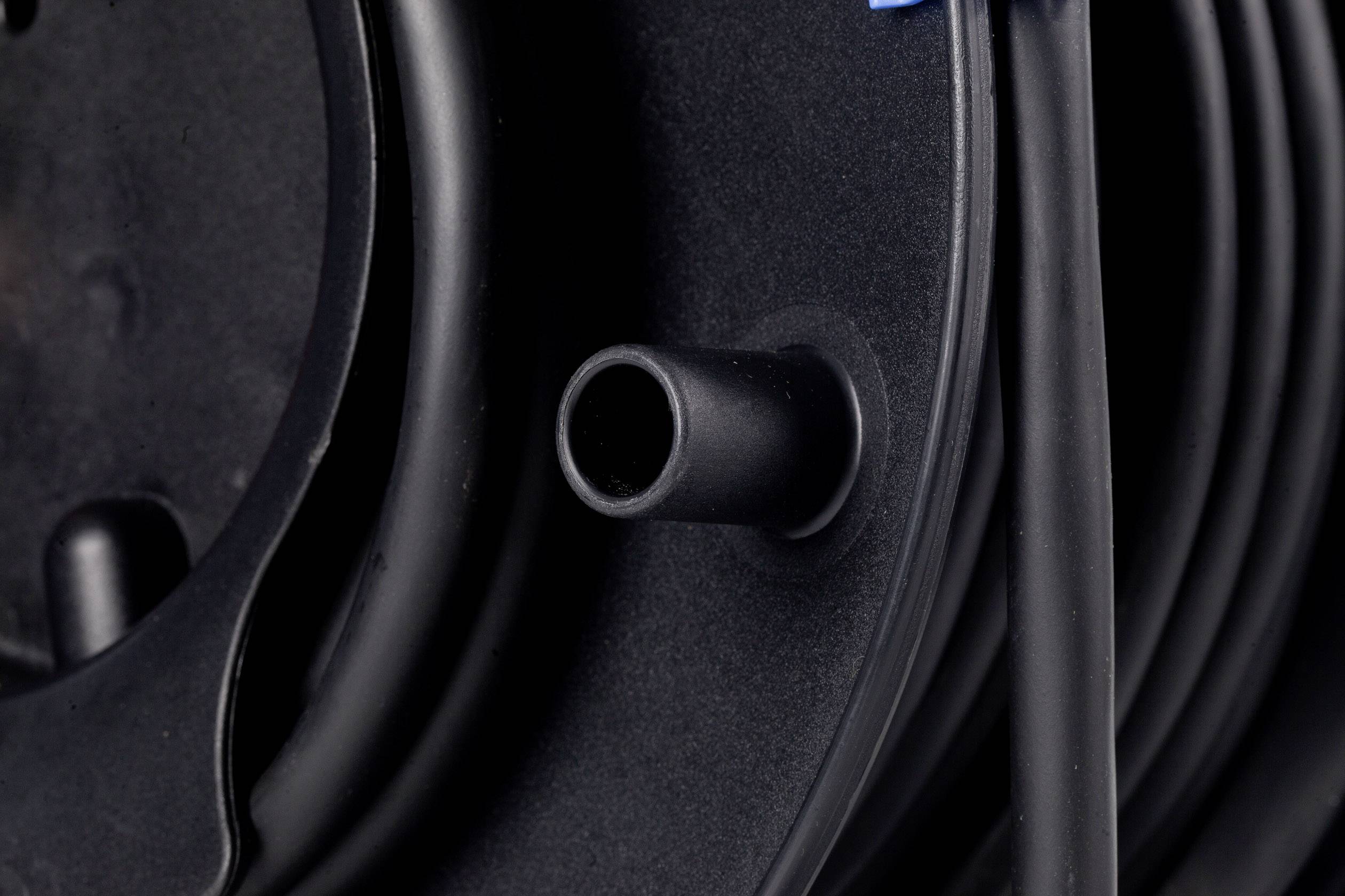 Nahaufnahme eines schwarzen Kabels, das auf einer Kabeltrommel aufgerollt ist. Hauptsächlich sichtbare Trommel und Kabel.