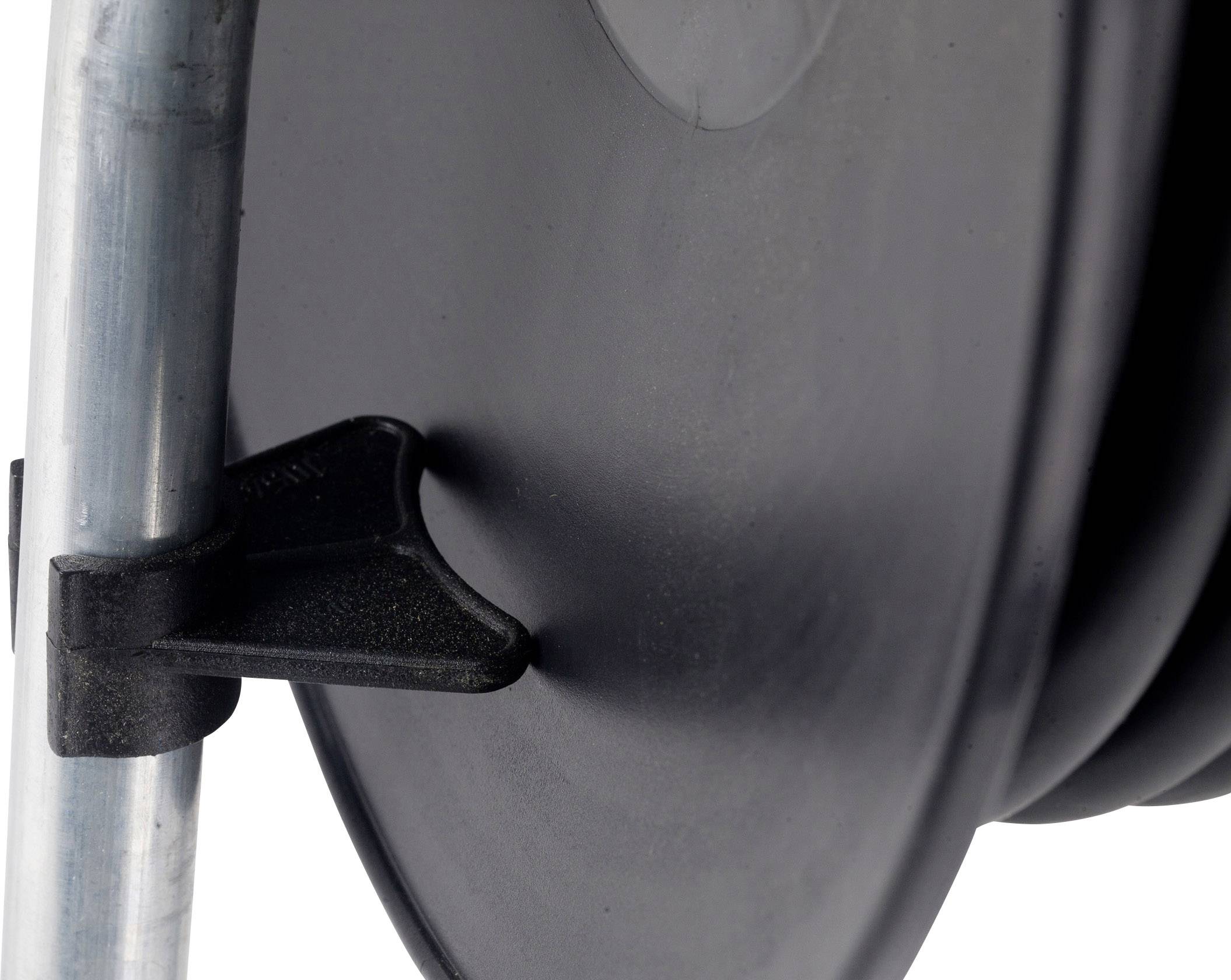 'Nahaufnahme einer schwarzen Kabeltrommel mit Halterung, befestigt an einem Metallrahmen.'