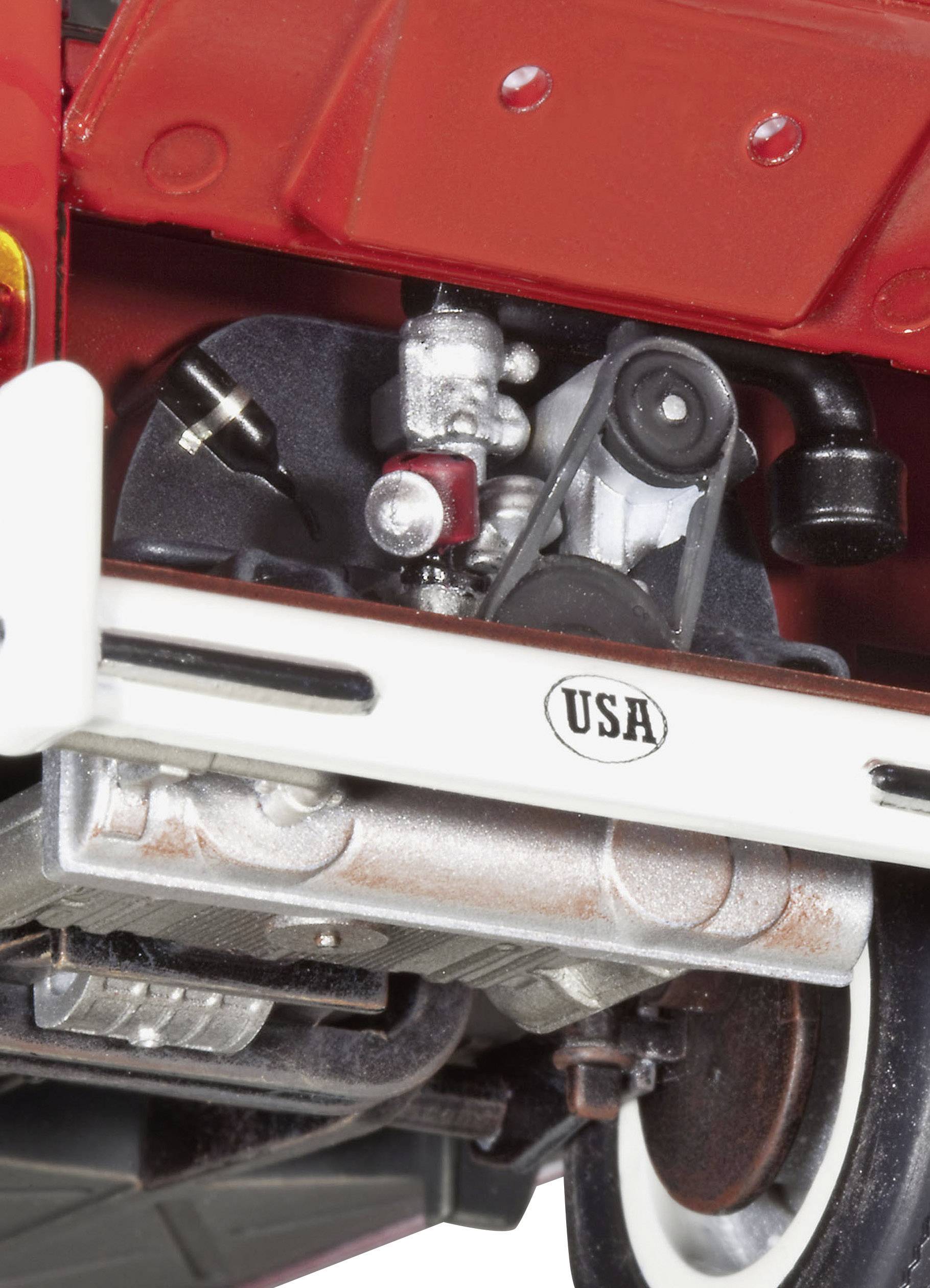 Nahaufnahme eines Oldtimer-Motorraums mit 'USA'-Plakette. Sichtbar sind technische Details wie Riemen und Zylinder. Fokus auf Mechanik.