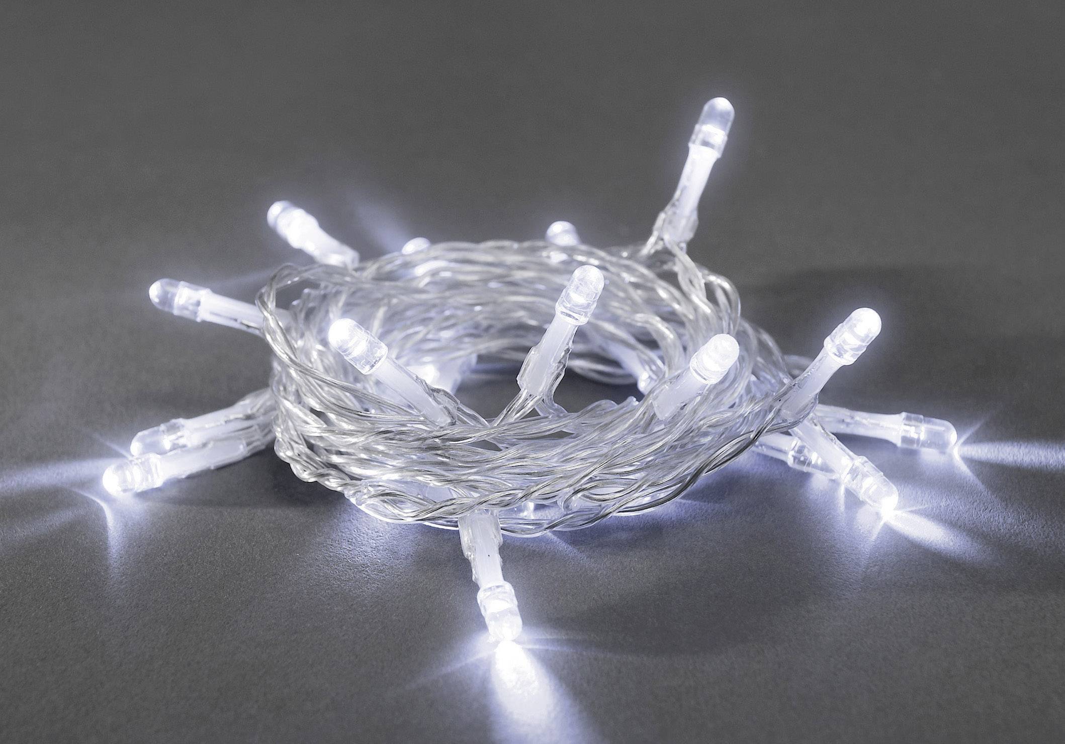 Eine zusammengerollte Lichterkette mit weißen LED-Lichtern, die auf einem grauen Hintergrund leuchtet.