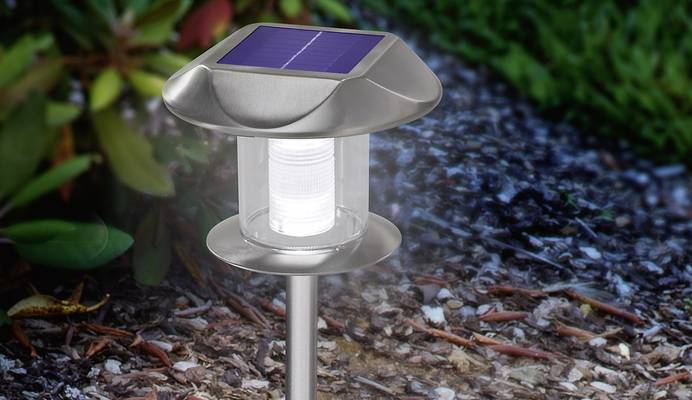 Solar-Leuchte mit Erdspieß im Garten befestigt