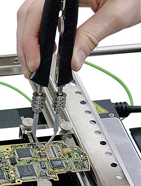 Eine Hand hält eine Pinzette und arbeitet an einer Computerplatine mit feinen elektrischen Komponenten.