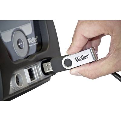 'Ein Hand steckt einen USB-Stick mit der Aufschrift "Weller" in einen USB-Anschluss eines Geräts.'