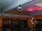 Spinning-Saal mit Spiegelkugel, bunter Beleuchtung und mehreren Spinning-Bikes. Atmosphärische Einrichtung für Musik und Bewegung.