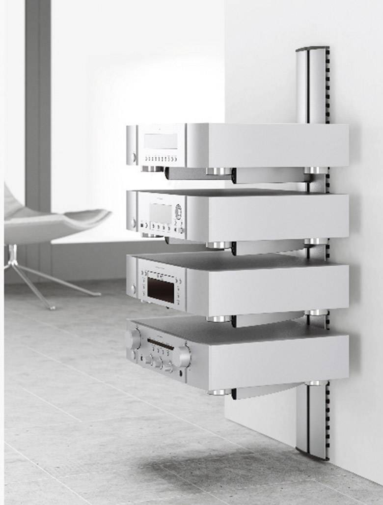 Ein modernes Hifi-Rack mit vier gestapelten Audiogeräten an einer Wandhalterung in einem minimalistisch eingerichteten Raum.
