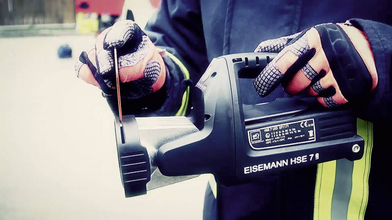 Eine Person in Schutzkleidung hält eine Rettungssäge der Marke EISEMANN HSE 7 bei einem Rettungseinsatz.