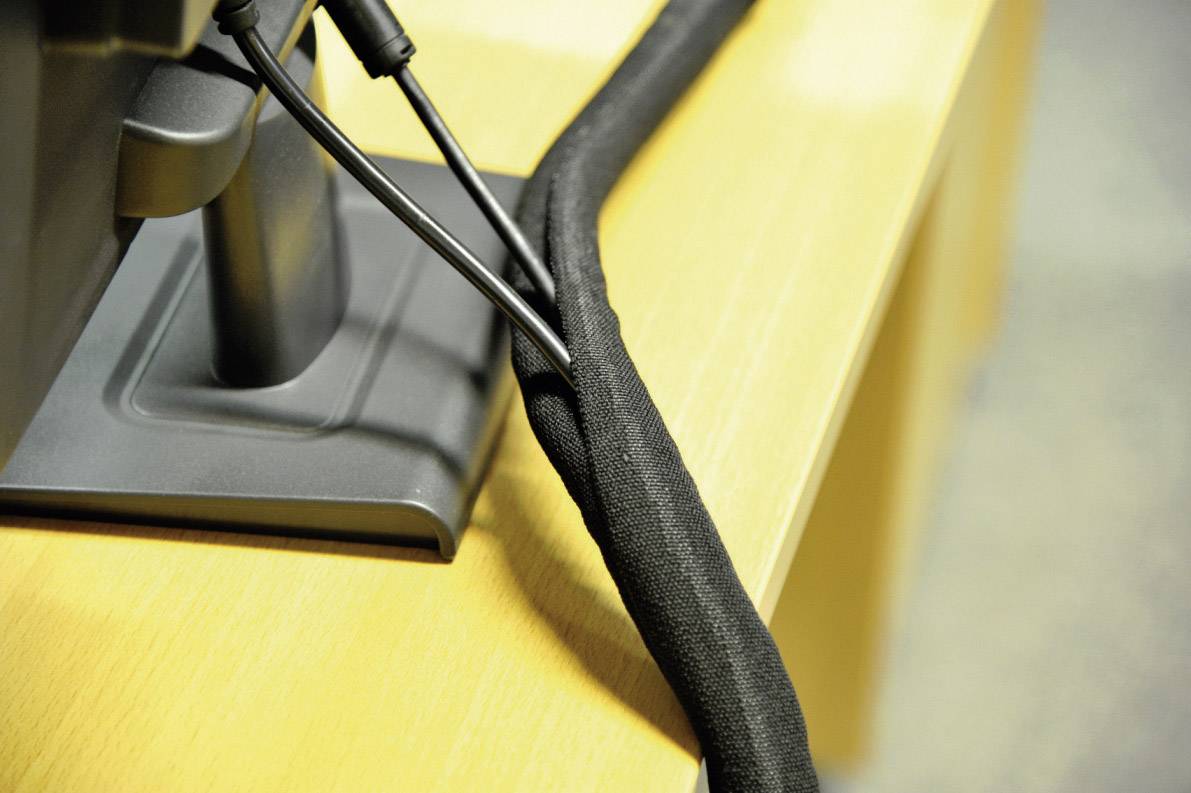 Kabelmanagement unter einem Schreibtisch, das Kabel sauber in einem schwarzen Kabelkanal gebündelt zeigt.