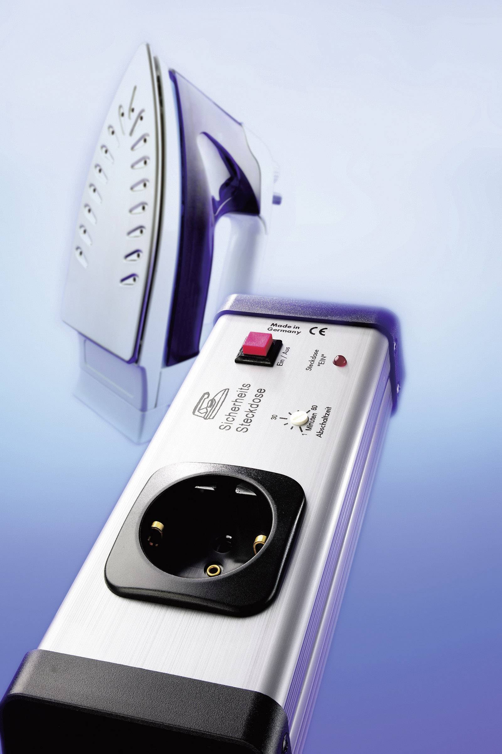 Ein Bügeleisen aufrecht mit einer Sicherheitssteckdose im Vordergrund, die einen Ein-/Ausschalter und einen Knopf zur Temperaturregelung hat.