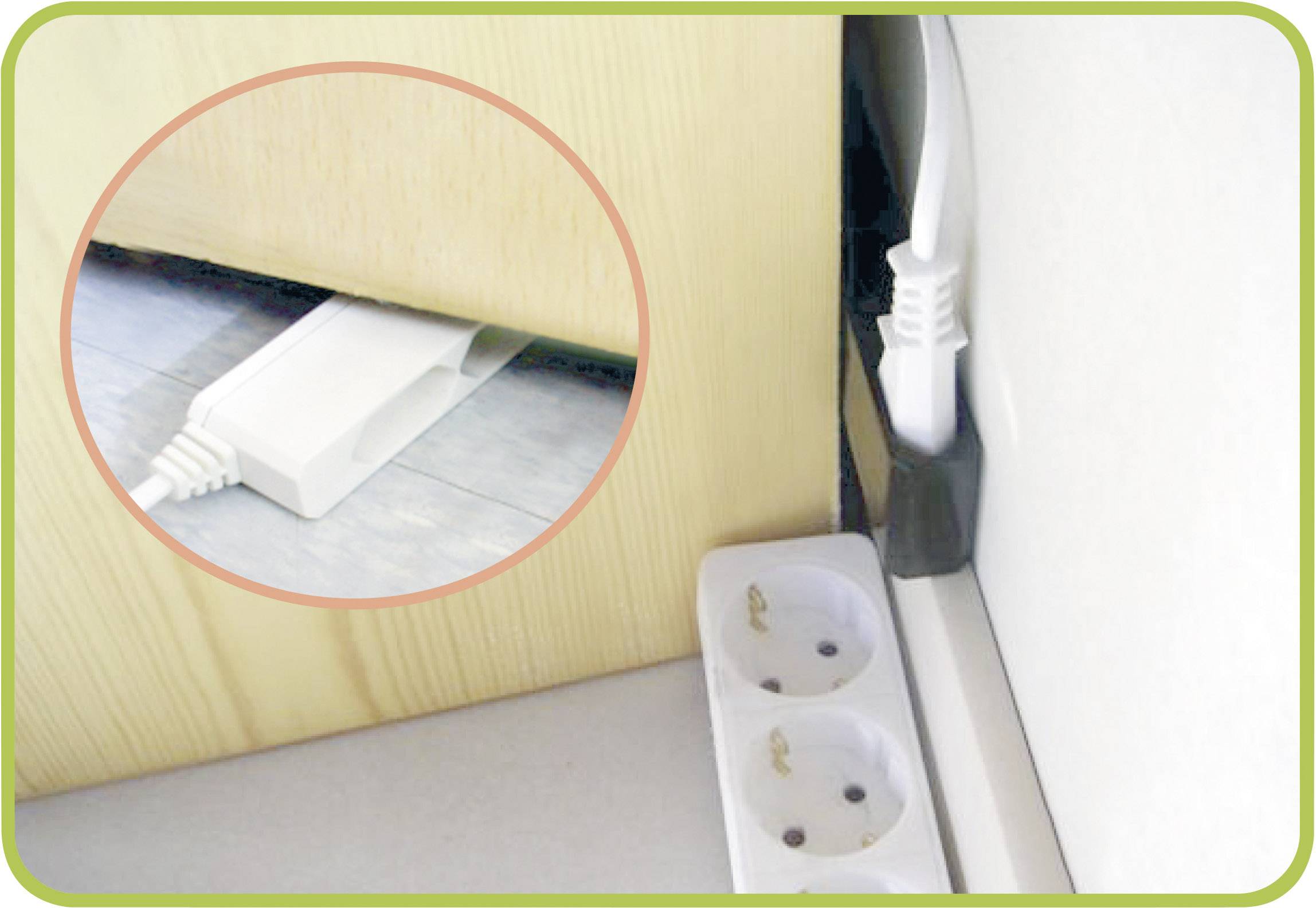 Ein flaches Verlängerungskabel verläuft unter einem Schrank und ist mit einer Steckdose verbunden. Im Vordergrund eine Doppelsteckdose.